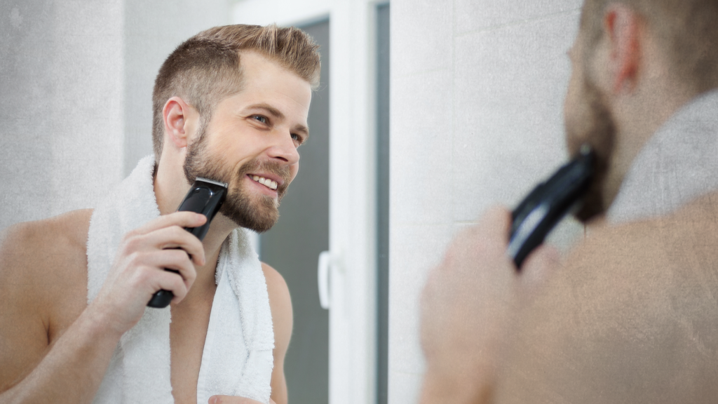 man trimming his beard in front mirror